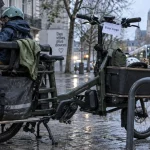 Vélo cargo nantes longtail avec 3 enfants, arceaux et bacs près de la rue